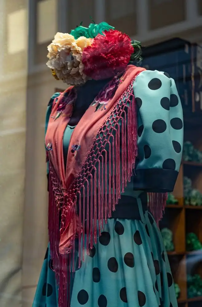 Close-up of Beautiful spanish blue flamenco dress with scarf in the window of a special clothing store.